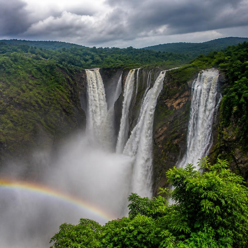 Mighty Jog Falls cascading down rocky cliffs with monsoon rainbow