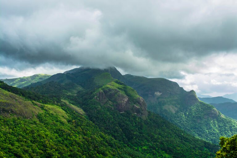 Verdant green mountain peaks wrapped in drifting mist