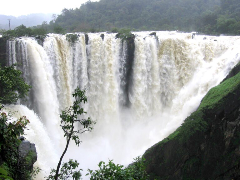A wide, powerful waterfall plunging down a rocky cliff